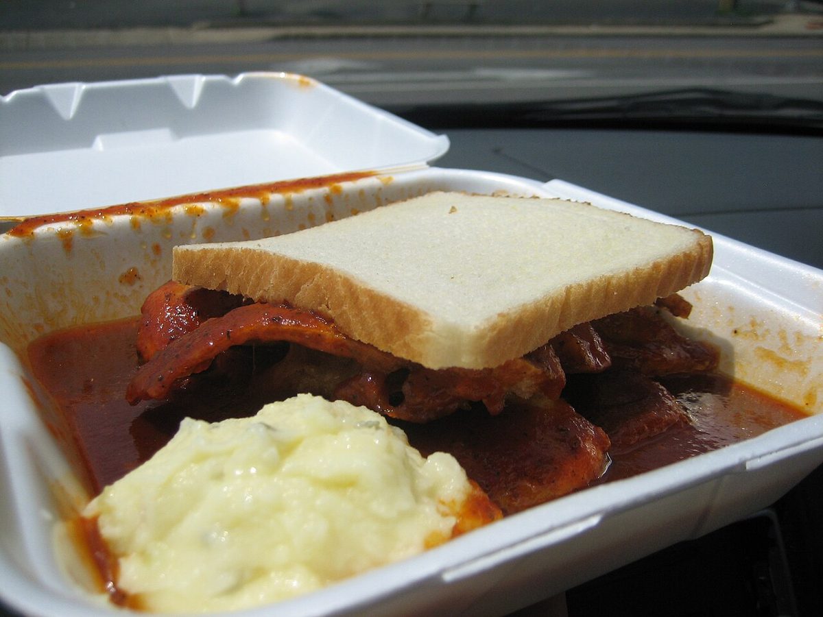 A St. Louis-style pig snoot sandwich in sauce on white bread with potato salad, from C&K Barbecue